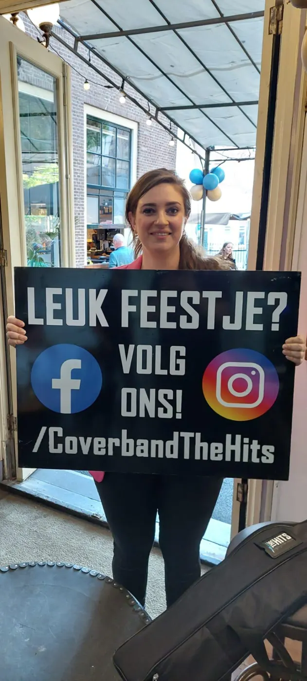 Vrouw toont een bord met de tekst Leuk feestje? Volg ons! met logo's van Facebook en Instagram bij de ingang van een café
